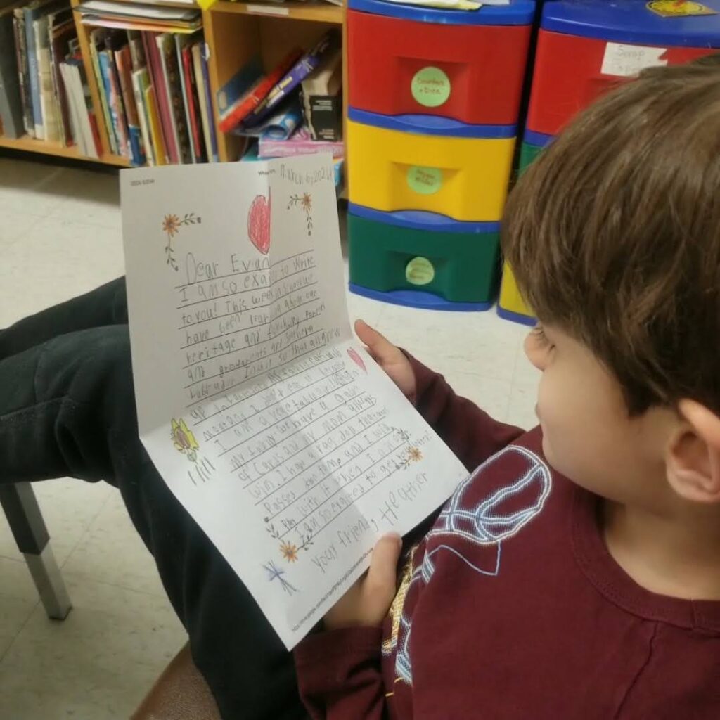 young boy reading a letter